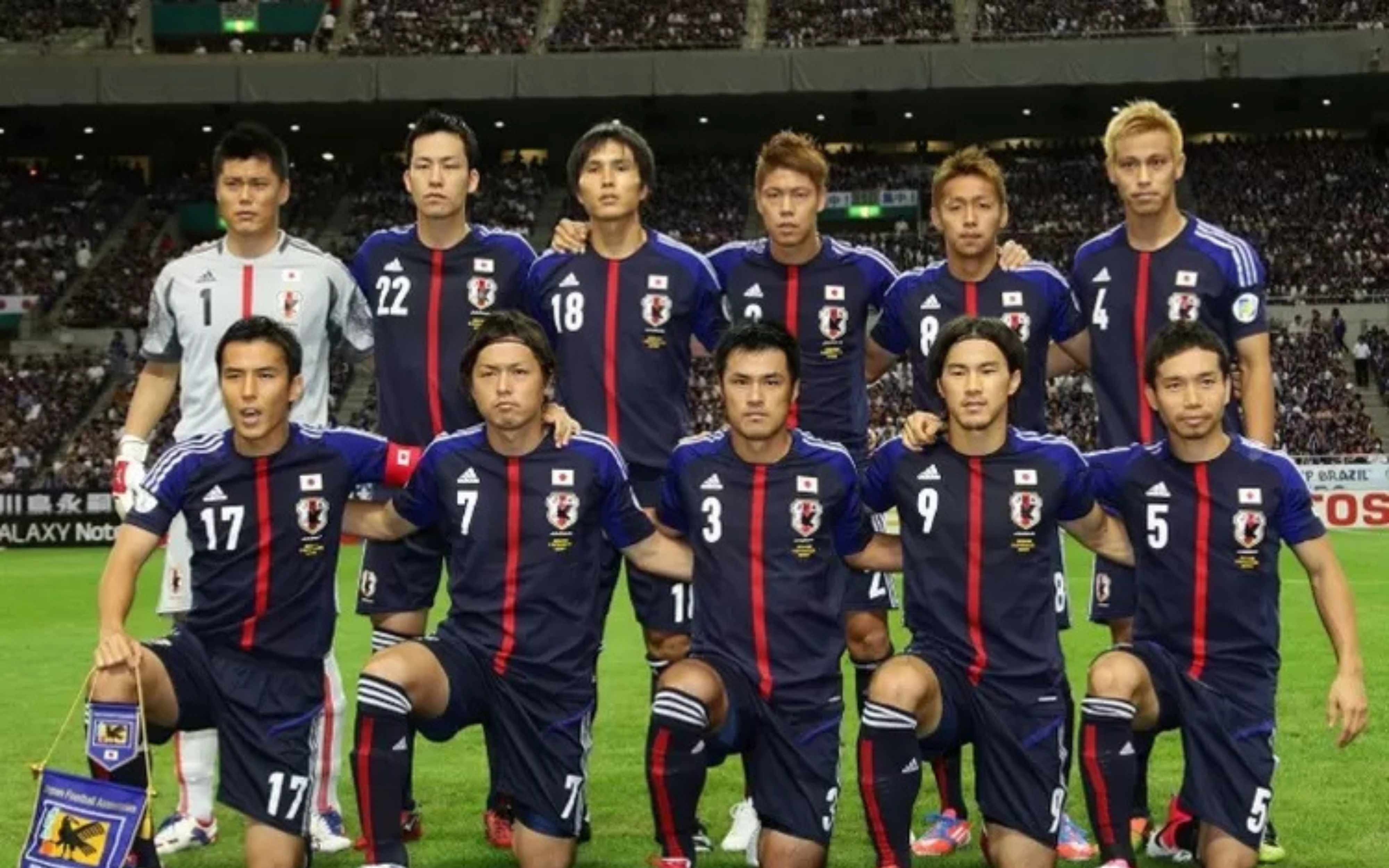 Tim nasional Jepang berfoto bersama sebelum pertandingan, mengenakan seragam biru dengan latar stadion