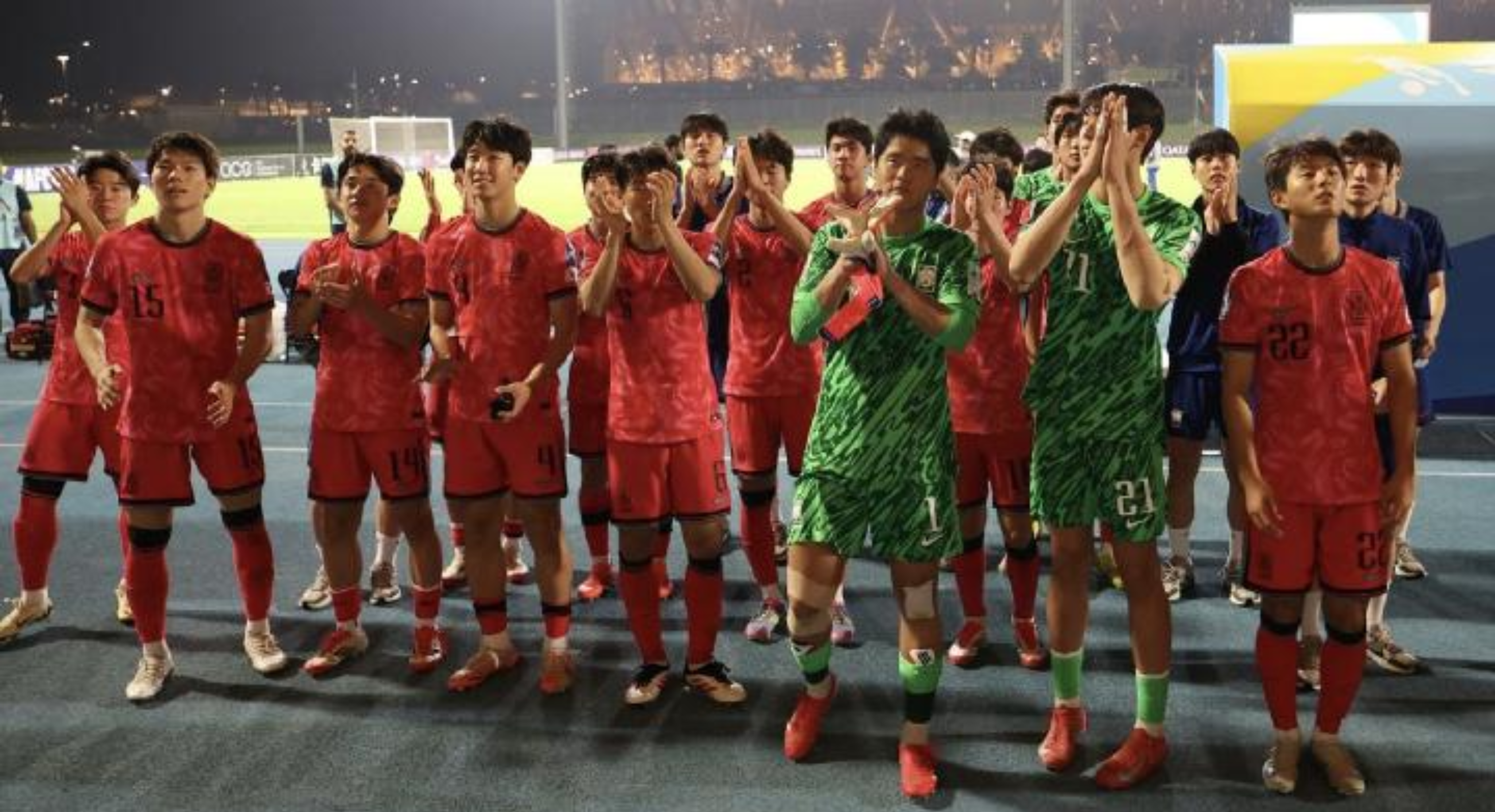 Gambar tim sepak bola berpose bersama di lapangan, mengenakan seragam merah dengan suasana tim yang penuh semangat