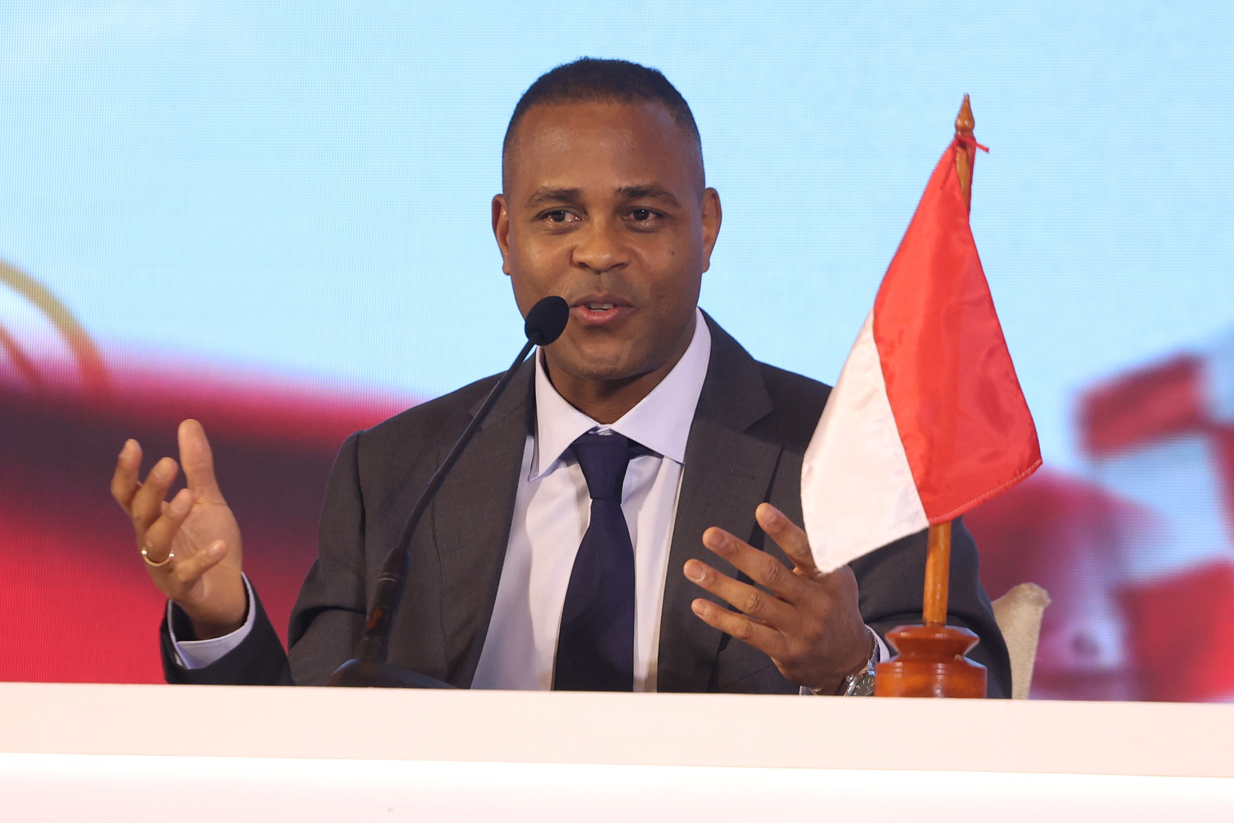 Patrick Kluivert memegang bendera Indonesia, simbol komitmennya sebagai pelatih baru Timnas Indonesia.