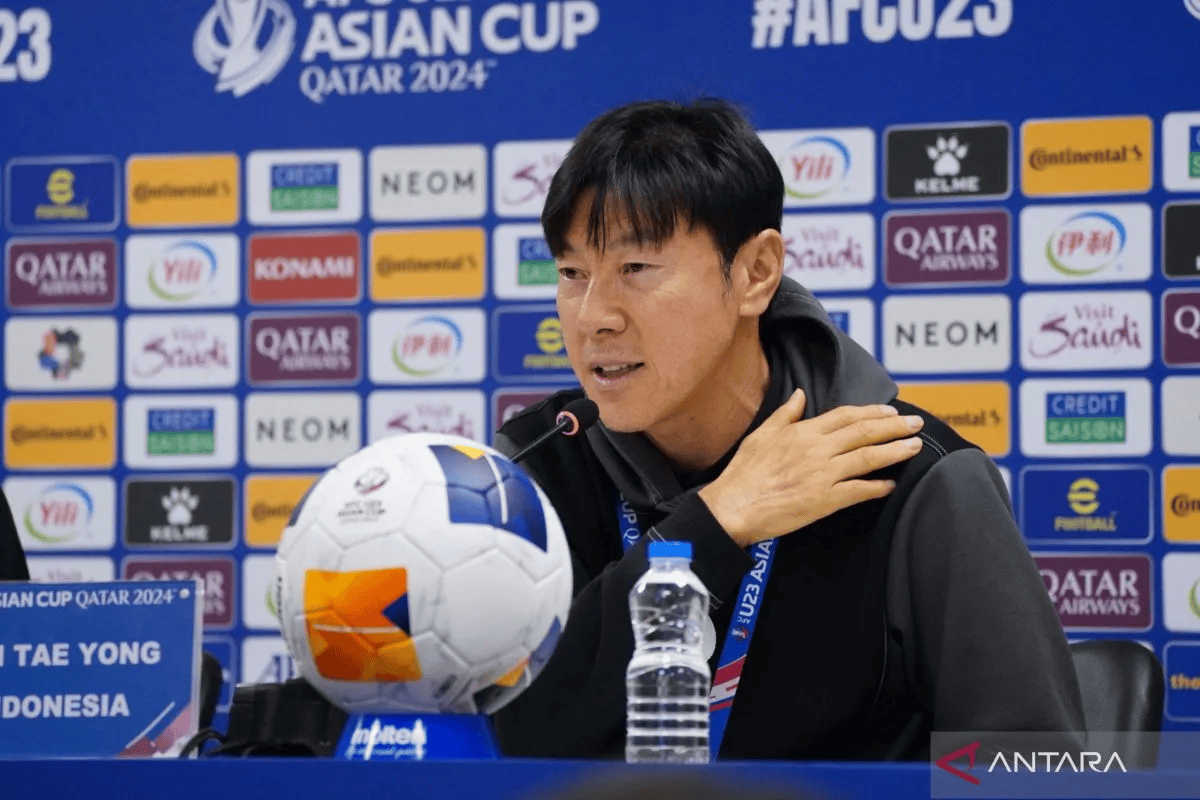 Pelatih Shin Tae-yong berdiri di pinggir lapangan mengenakan jaket Timnas Indonesia, memberikan instruksi kepada para pemain U-23 saat sesi latihan jelang Kualifikasi Piala Asia U-23 2026.