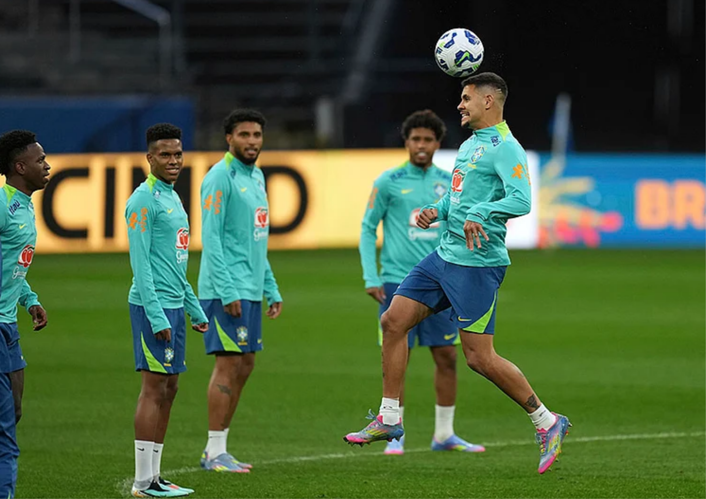 Pemain muda Brasil berlatih serius di lapangan menjelang kualifikasi Piala Dunia 2026 dengan pelatih memberi instruksi taktik.