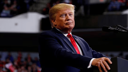 Donald Trump speaking at a podium during a press conference, announcing the formation of a new organization to oppose potential sanctions against Israel regarding the 2026 FIFA World Cup.