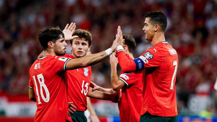 Cristiano Ronaldo dan rekan setimnya merayakan gol untuk Timnas Portugal, berpelukan di lapangan