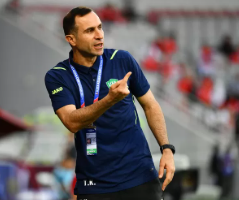 Potret manajer sepak bola Uzbekistan, Timur Kapadze, sedang memberikan instruksi di pinggir lapangan.