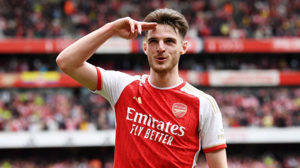 Pemain sepak bola Arsenal, Declan Rice, merayakan gol dengan mengepalkan tangan dan melambaikan tangan ke udara.